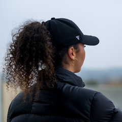 Person wearing The Magni-Strip® Lifestyle Cap Black and black jacket