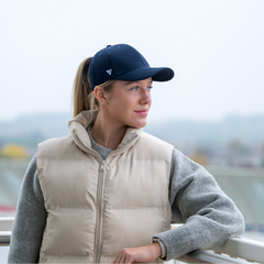 Woman wearing The Magni-Strip® Lifestyle Cap Navy and beige puffer outdoors