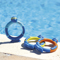 Colorful inflatable pool toys on a stone ledge with a pool