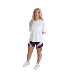 Woman wearing a white t-shirt and navy and pink Hapola shorts
