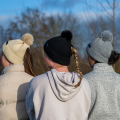 The Magni-Strip® Bobble Hat Black, Beige and Grey worn by women outdoors