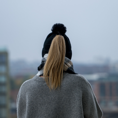 Person wearing The Magni-Strip® Bobble Hat Black with grey coat
