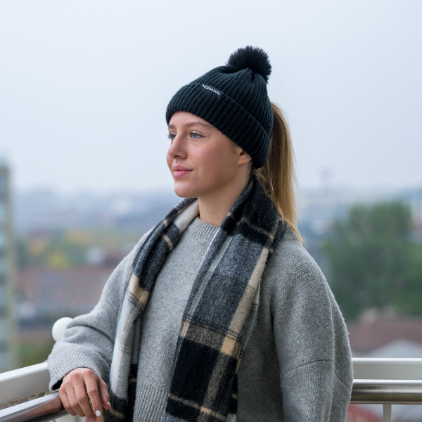 The Magni-Strip® Bobble Hat Black worn by woman outdoors