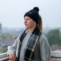 The Magni-Strip® Bobble Hat Black worn by woman outdoors