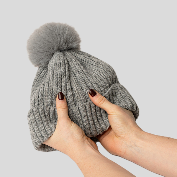 Magni-Strip® Bobble Hat Grey held by hands