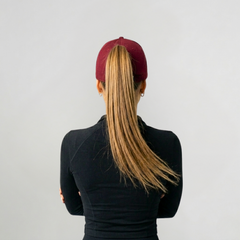 Woman turned away wearing Versatail Berry Red cap