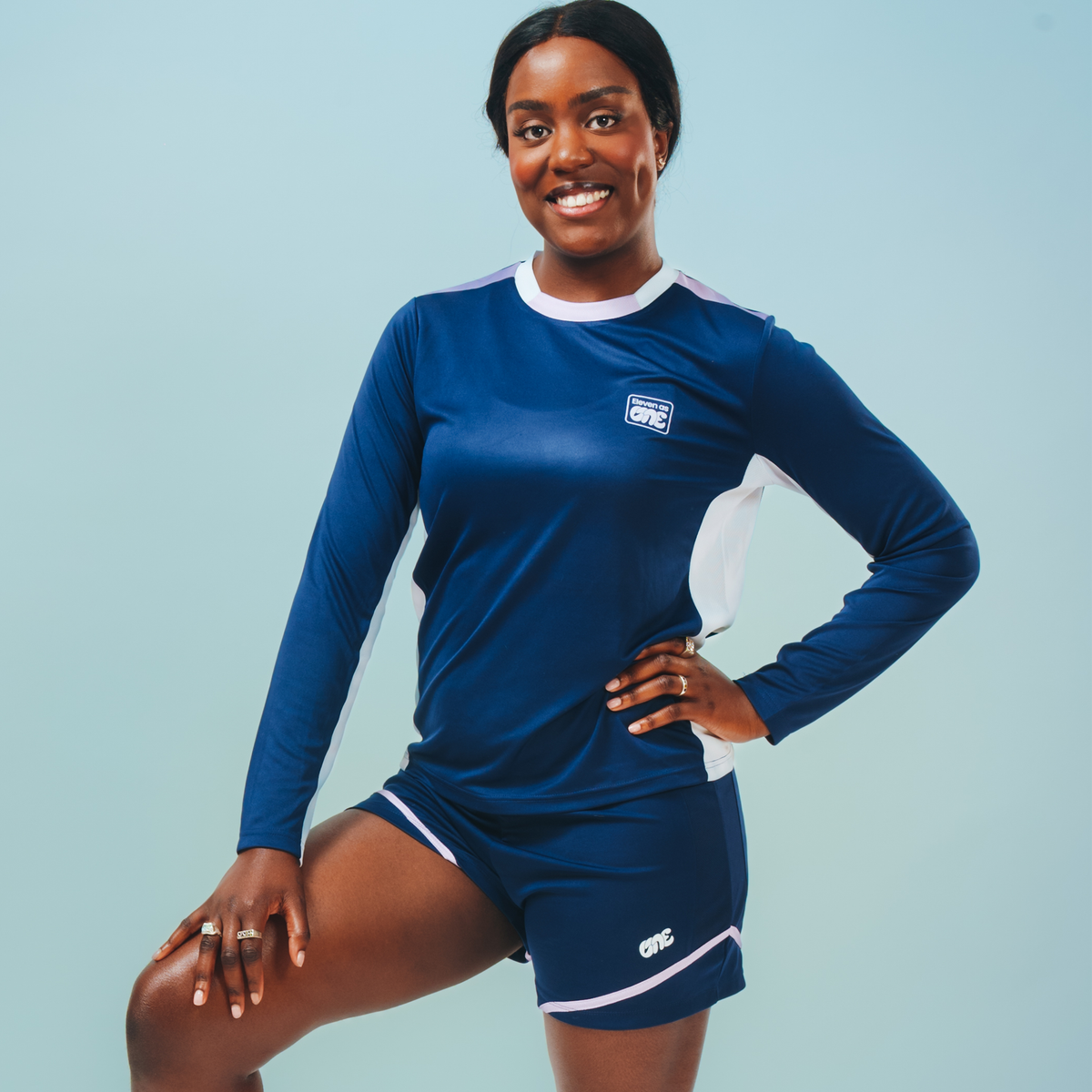 Long sleeved navy blue training top with white trim and white Eleven as One logo. Model is also wearing the Eleven as One shorts, the full kit. 