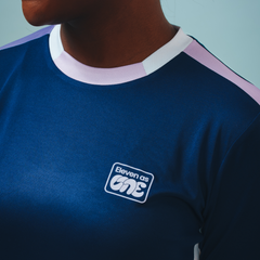 Eleven as One white logo on blue long sleeved training top showing white shoulder and neck trim.