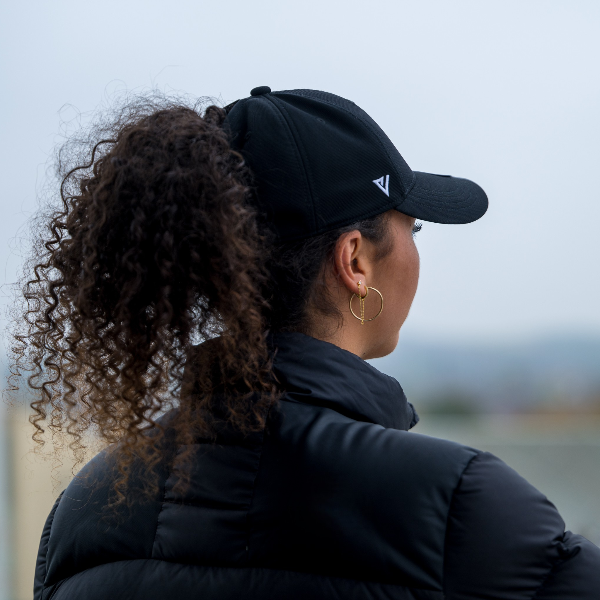 Person wearing The Magni-Strip® Lifestyle Cap Black and black jacket 