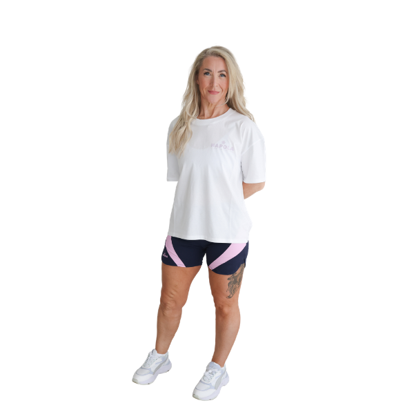 Woman wearing a white t-shirt and navy and pink Hapola shorts