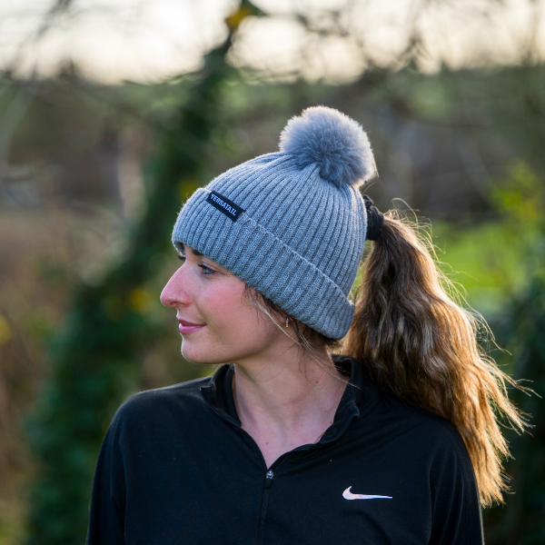 Woman wearing The Magni-Strip® Bobble Hat Grey outdoors