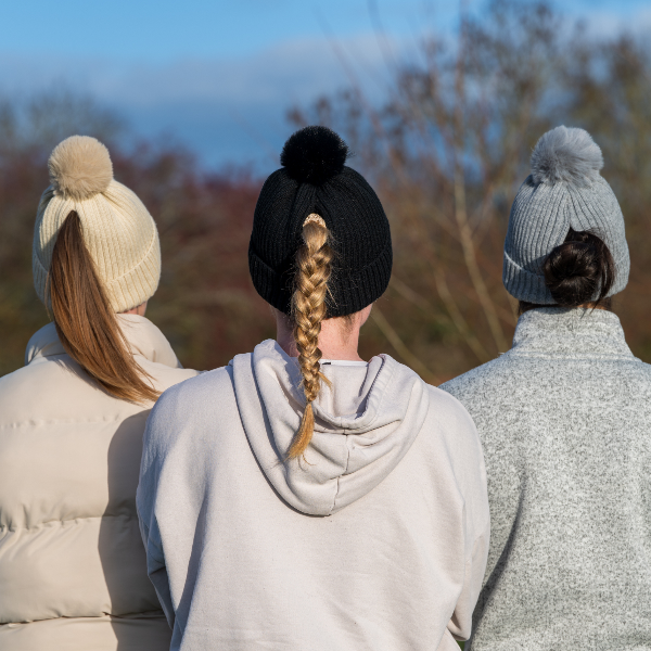 Three people wearing Black, Beige and Grey Magni-Strip® Bobble Hat Black and coats looking out over a scenic landscape.